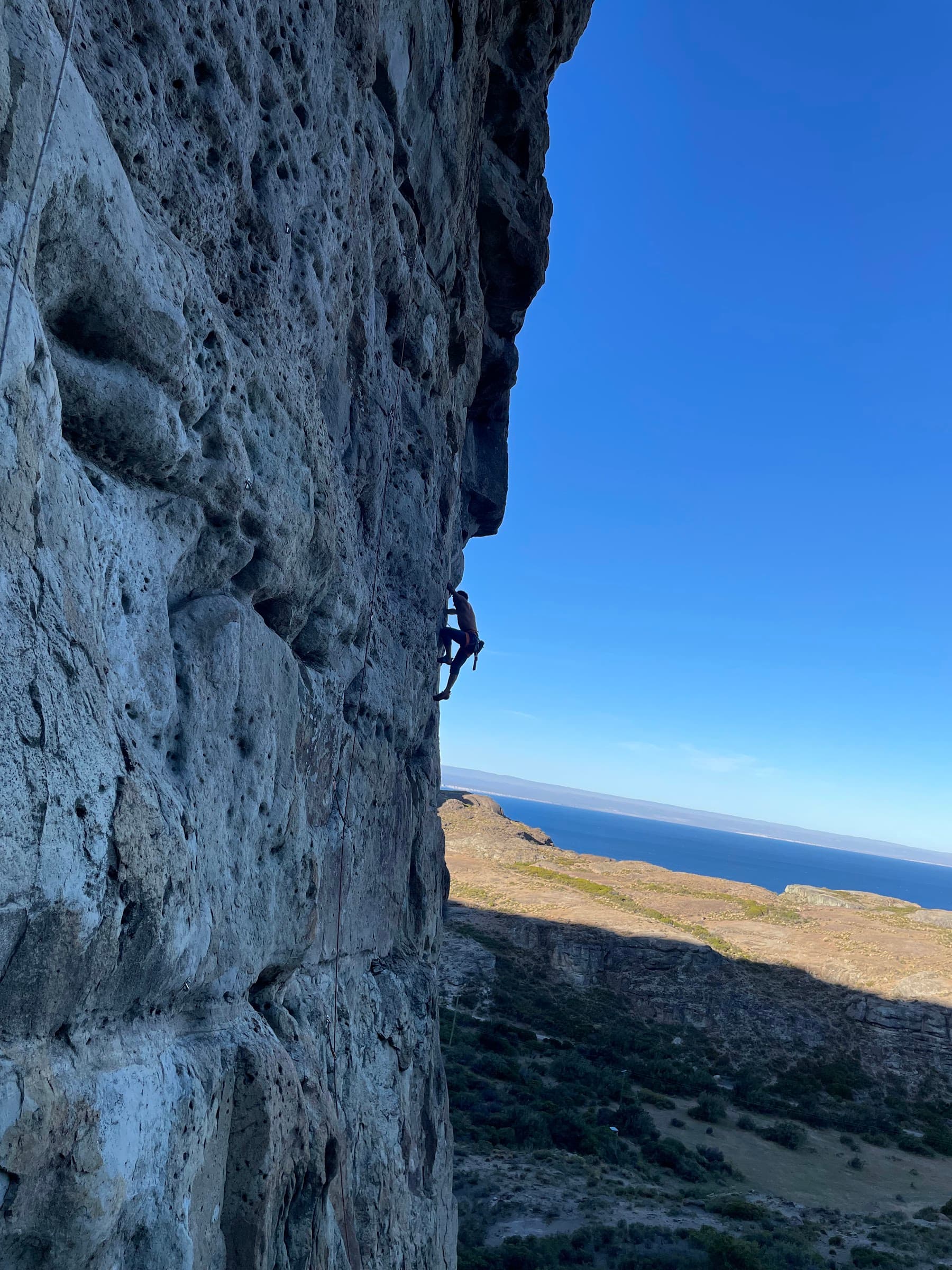 Escalador en la pared, con el lago al fondo